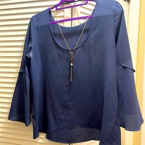 Navy blue blouse with long gold necklace attached. Very flattering.